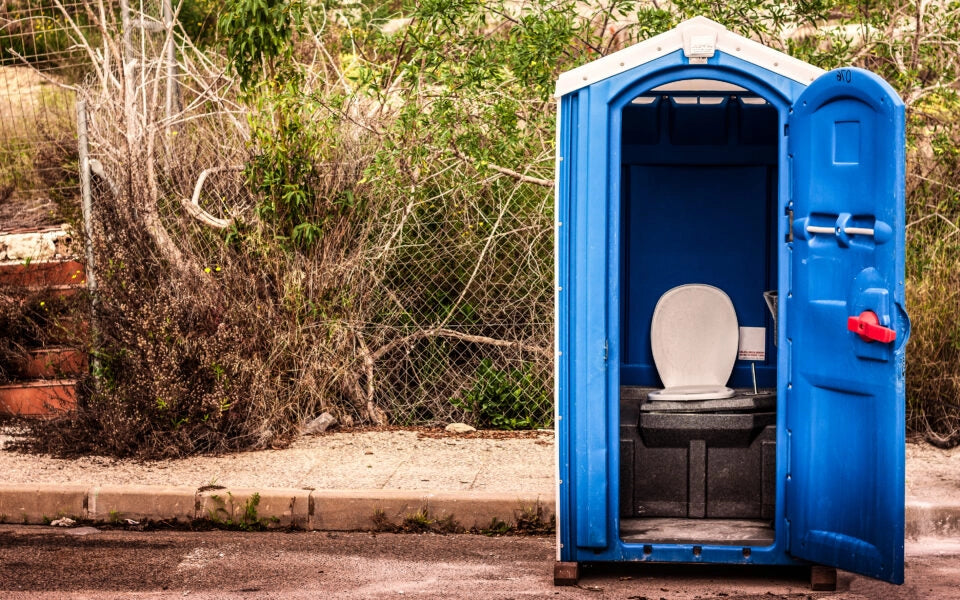 Blue Dixie toilet with open door at the roadside