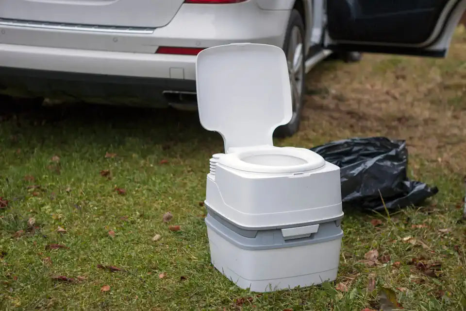 Chemical camping toilet outside in front of car