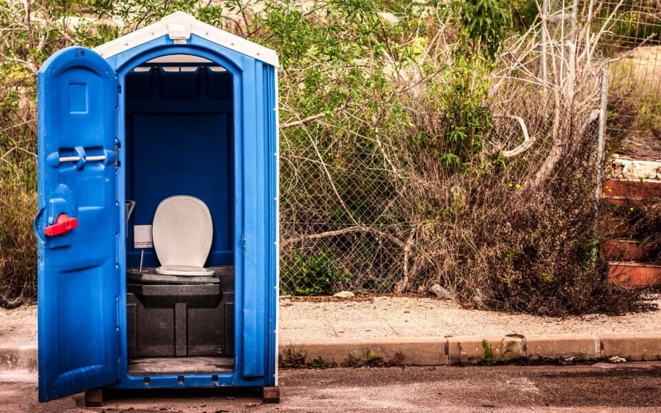 Dixie Toilette mit offener Tür steht am Straßenrand