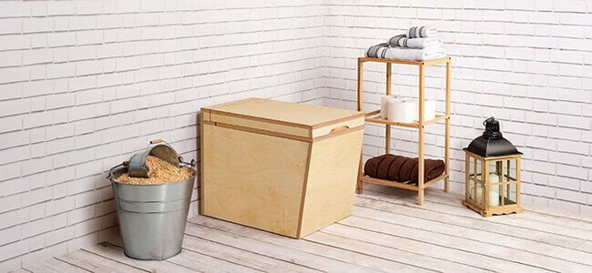 Composting toilet TROBOLO LuweBloem in a room next to zinc bucket